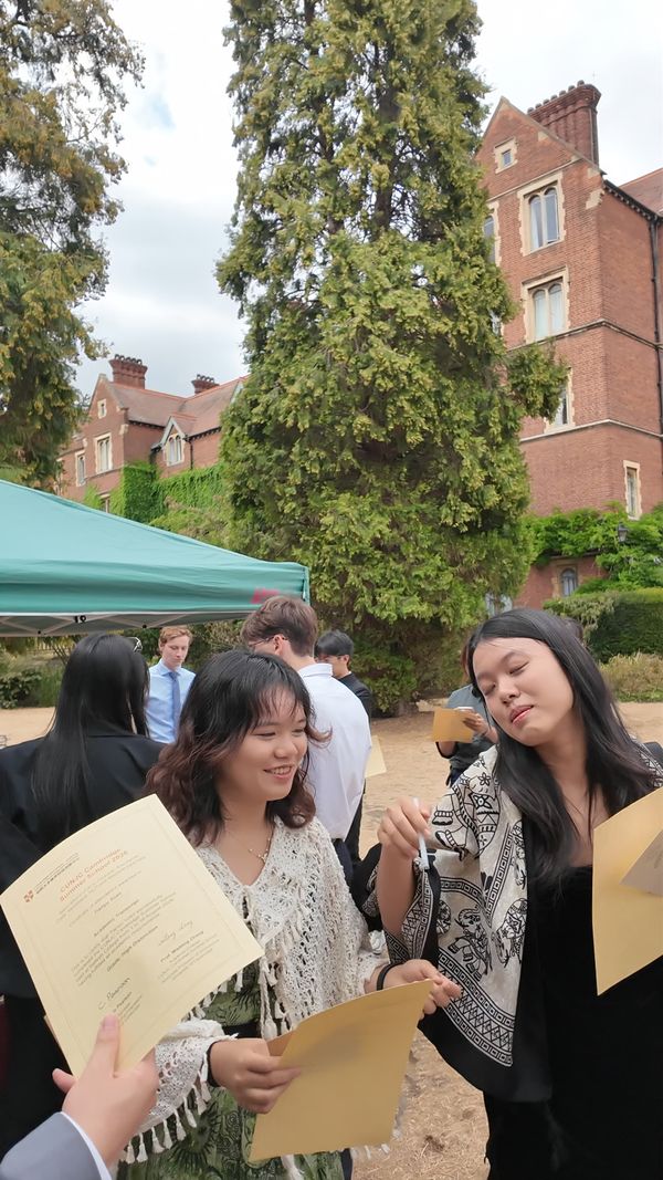 Students looking at their certificates at the garden party