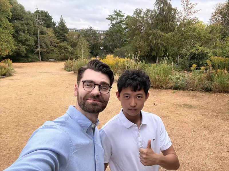 A teacher and a student taking a selfie in a garden
