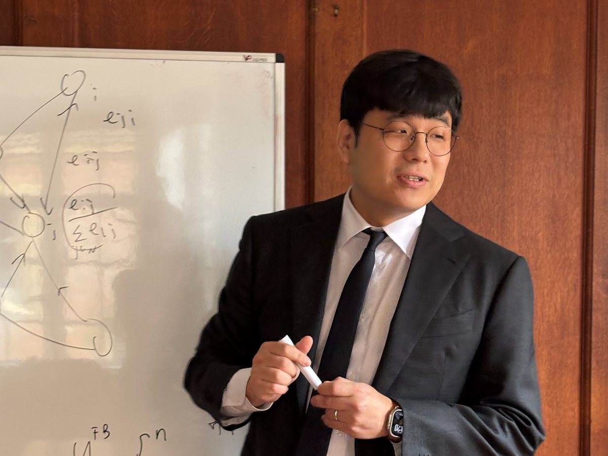 A teacher explains a model at the whiteboard